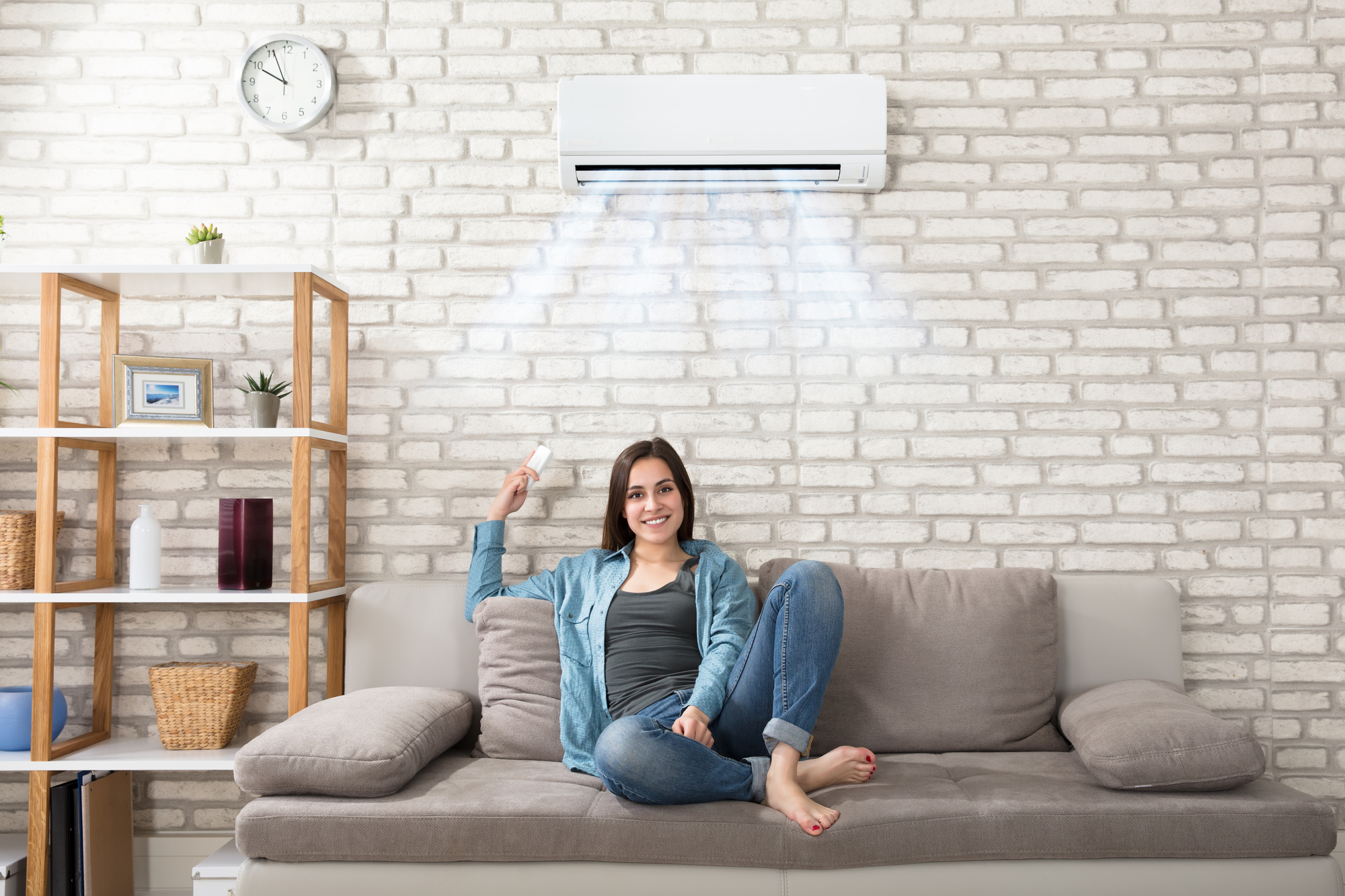 Happy Young Woman Relaxing Under The Air Conditioner